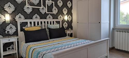 菲乌米奇诺皮科罗住宿加早餐旅馆的一间卧室配有一张黑色和白色壁纸的床