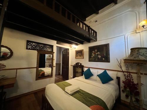 曼谷布鲁斯103号酒店的一间卧室配有一张带蓝色枕头的大床