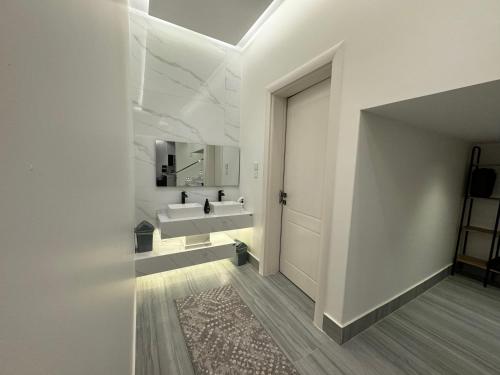 布赖代شاليه الرتاج الفندقي的白色的浴室设有水槽和镜子
