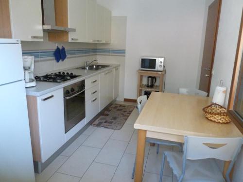 滕诺Appartamento Mora的厨房配有白色橱柜和带水槽的桌子