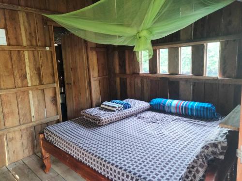 瓜隆岛Friend of Nature Bungalow的小木屋内一间卧室,配有两张床