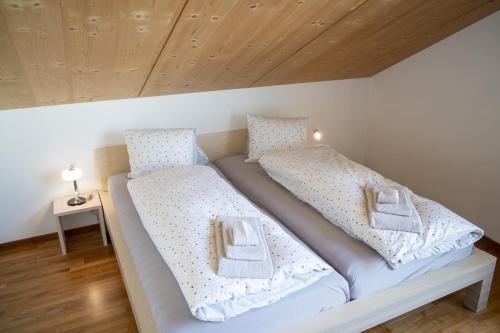 施库尔Chasa Bagnera 174的一间卧室配有两张带白色床单的床