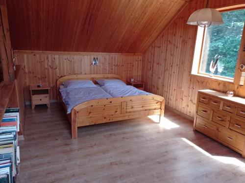 HraniceChata Ujo的木制客房内的一间卧室,配有一张床