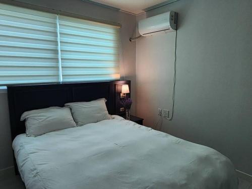 水原市Suwon station City House的卧室配有白色的床和窗户。