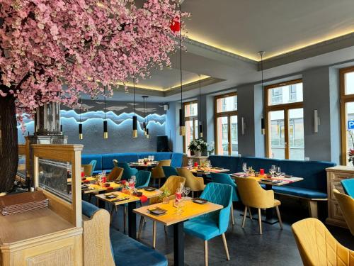 莱门Zur Krone Leimen的一间带桌椅和粉红色鲜花的餐厅