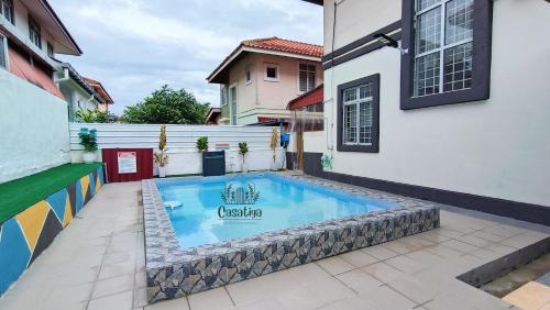 马六甲Casatiga Pool Homestay in Melaka Musliim Only的一座房子庭院中的游泳池