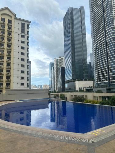 马尼拉Affordable Staycation Airbnb BGC的一座位于城市的游泳池,有高大的建筑