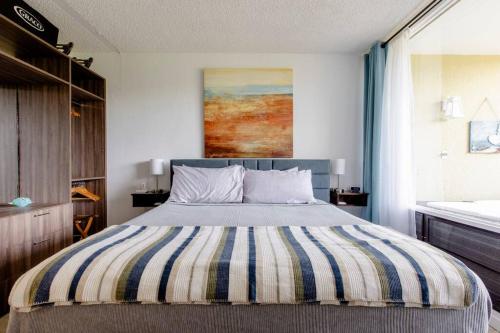 乌马考Carey Beach Villa的一间卧室配有一张带条纹毯子的大床