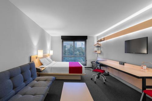 瓜达拉哈拉City Express Plus by Marriott Guadalajara Expo的配有一张床和一张书桌的酒店客房