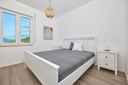 马尔切西内Lake View Luca Apartment的白色的卧室设有床和窗户