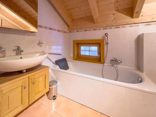 沃尔夫斯堡1A Chalet Koralpenzauber - Wandern, Sauna, Grillen mit Traumblick的浴室配有盥洗盆和浴缸。