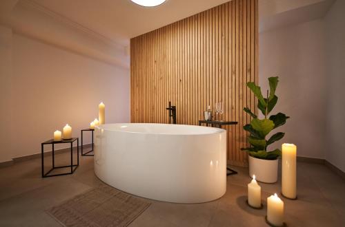 贝希特斯加登纽豪斯高级酒店的浴室设有白色的浴缸和蜡烛