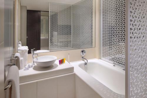 迪拜Hotel Boulevard, Autograph Collection的浴室配有白色浴缸和水槽