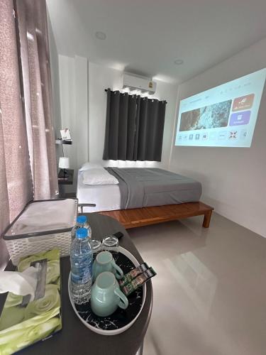 Ban Noi Pho KhamJanis Home的小房间设有一张床和一张桌子,配有带茶壶的托盘