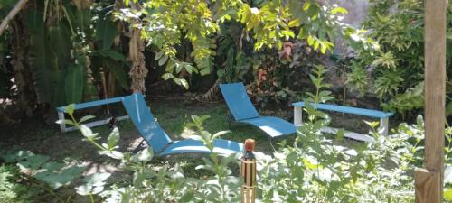 Grande AnseChambre d'hôtes pieds dans l'eau的花园里的三把蓝色椅子