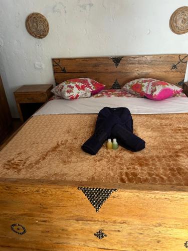 MatmataLars homestead的一张带木头床头板和衣服的床