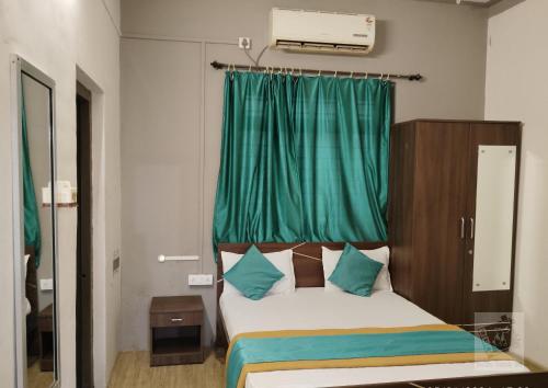 奥兰加巴德Hotel Natraj - Railway Station的一间卧室配有一张带绿帘的床