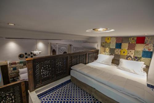 非斯Darif's Riad & Spa的一间卧室配有一张大床和木制床头板