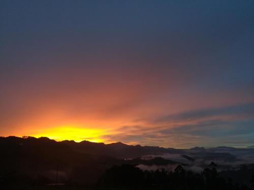 哈普特莱Dinu Homestay的日落和日落,在群山上
