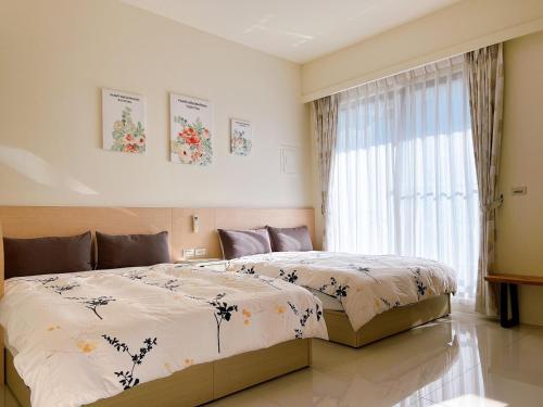 罗东镇遇巧寓可使用國旅卡有代辦泛舟賞鯨獨木舟等活動的一间卧室设有一张大床和一个窗户。
