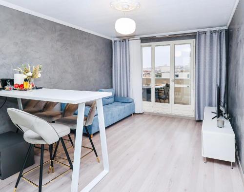 维勒班Appartement moderne, proche du Parc de la tête d'Or et de Lyon的客厅配有白色桌子和蓝色沙发