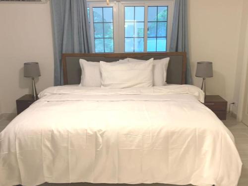 罗克桑德Suites Pineapple的一张白色大床,配有白色床单和枕头