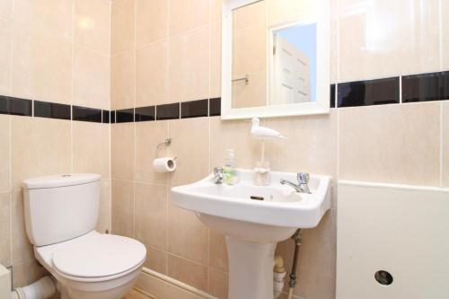 南安普敦Pebbles guest house的一间带卫生间、水槽和镜子的浴室