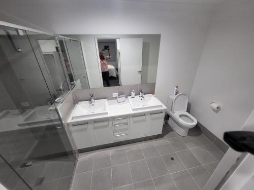 亨利布鲁克Comfort oasis family getaway的浴室设有2个水槽、卫生间和镜子。