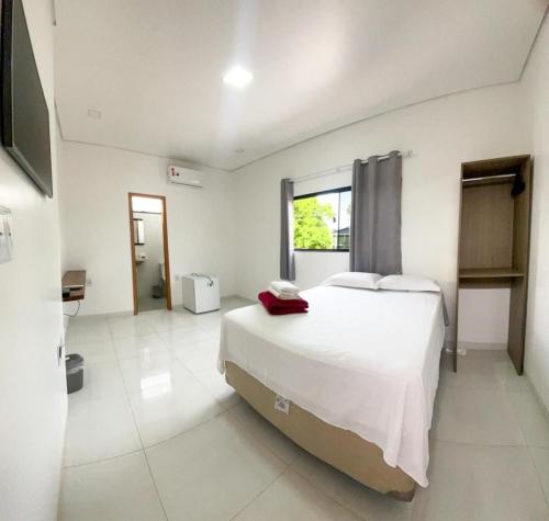 里约布兰科Pousada Amazônia的白色卧室设有一张大床和电视。