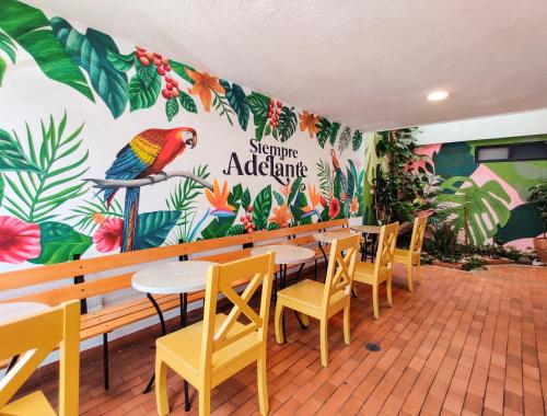 布卡拉曼加Zamia Hostel的餐厅设有桌椅和色彩缤纷的墙壁