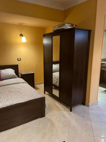 开罗Heliopolis Rock Residence的一间卧室配有一张床和一个带镜子的橱柜