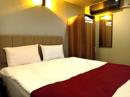 YıldırımGrand Marrakech Hotel的一间卧室配有一张带白色和红色床单的大床