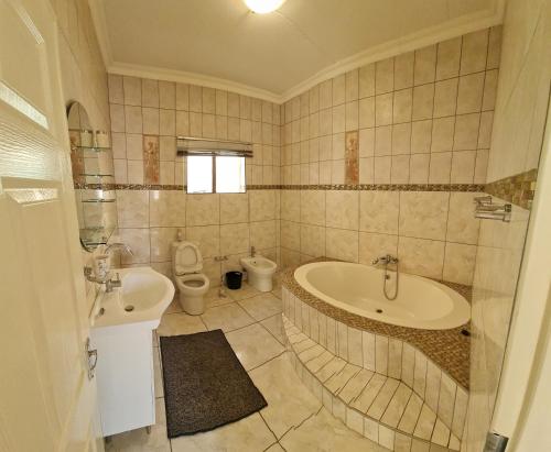 温特和克Garden Oasis Cottage的带浴缸、卫生间和盥洗盆的浴室