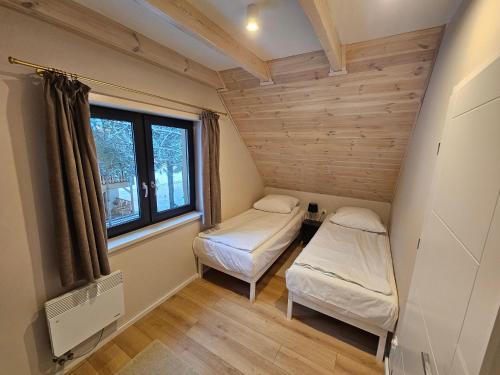 齐泽图霍尔斯凯Osada Kukówko的小房间设有两张床和窗户