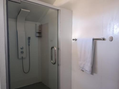 普诺Hanan Pacha Lodge的玻璃门淋浴和白色毛巾