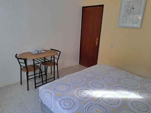 波尔蒂芒Casa Rochinha的卧室配有一张床和一张桌子及椅子