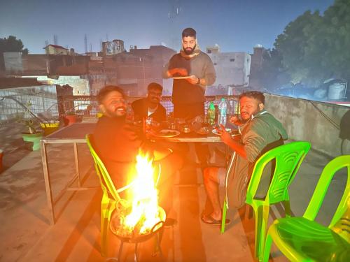 奥拉奇哈Orchha Best Homestay的一群人坐在桌子旁,火上浇油