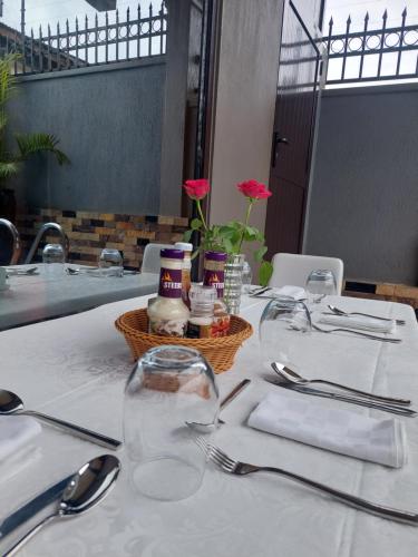 恩德培ENTEBBE STAY Apart-Hotel的一张桌子,上面有白色的桌布和一篮子的食物