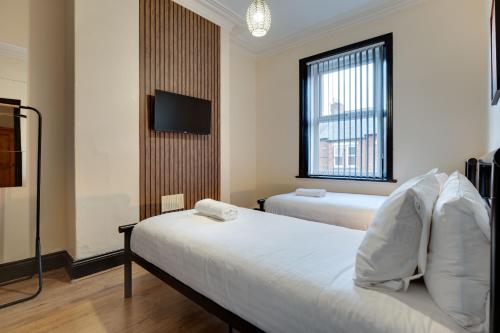泰恩河畔纽卡斯尔Newcastle CITY Apartments 35的酒店客房设有两张床和一台平面电视。