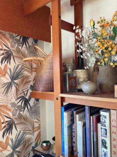 维里尔·杜·拉克Chambre privée dans Maison Familiale的书架上放着书和鲜花