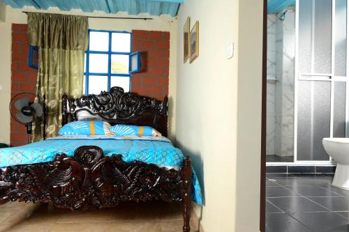 ChachagüíAlex Country House的一间卧室配有一张带蓝色棉被的床和窗户。