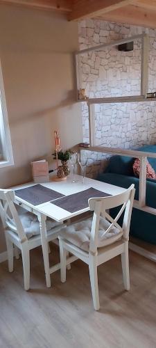 托伦Tiny House Tholen的客厅配有白色的桌椅