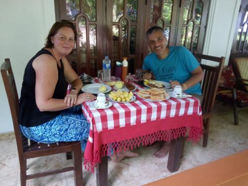 锡吉里亚SMW Lodge Sigiriya的坐在餐桌旁吃饭的男人和女人
