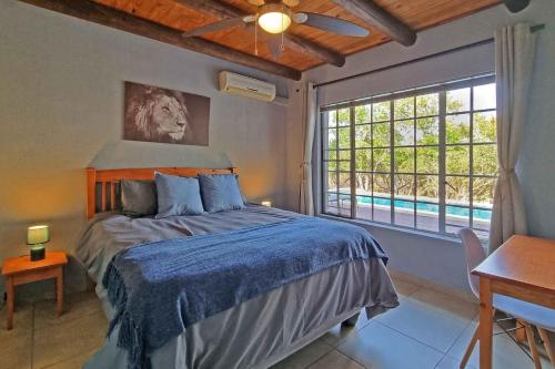 玛洛斯帕克Greater Kruger View - Luxury Bush Villa的一间卧室设有一张床和一个大窗户