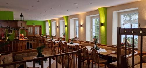 OlbersdorfOlbersdorfer Hof的餐厅设有桌椅和绿色的墙壁