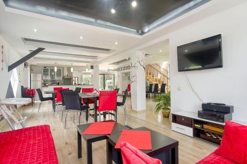 莫伊西德约斯Casa Preto E Branco的客厅配有红色家具和平面电视