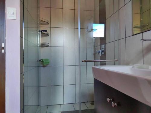 埃雷迪亚видовая квартира в Heredia的一间带玻璃淋浴和水槽的浴室