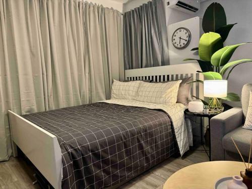 马尼拉Modern Stay的一间卧室配有一张床、一张沙发和一个时钟