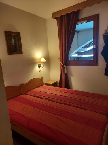 莱德萨阿尔卑斯T3 Les deux Alpes Vallée Blanche的一间卧室设有红色的床和窗户。