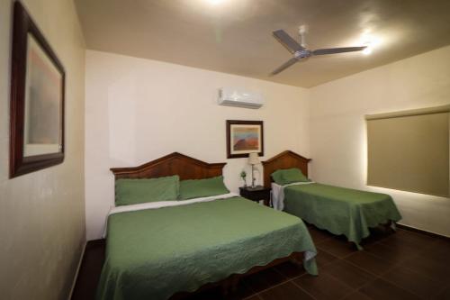 Hotel Villa Dominguez的一间卧室配有两张床和吊扇